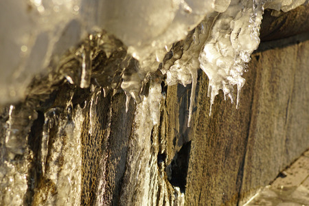 Icicle ice stalactite that forms at the edges of the hanging items, on rocky ledges, and coastal cliffs, wires, tree branchesの写真素材