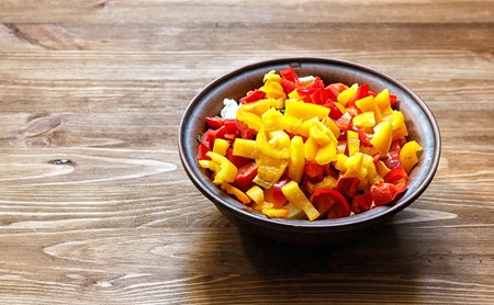 Clay bowl with a fresh salad on a wooden table.の写真素材