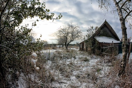 Backyard rustic old hut. Winter landscape. Clouds skyの写真素材