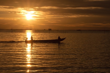Fishermen boat in sunset の写真素材