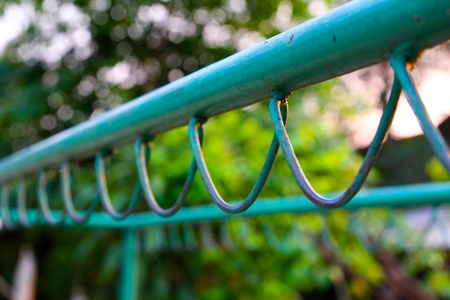 Wire fence with green on backgroundの写真素材