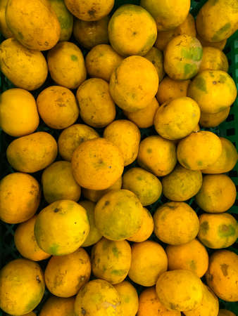 Close up of fresh orange fruit at the market. Orange background.の写真素材