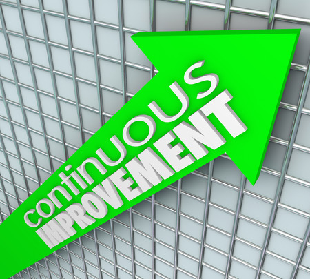Continuous Improvement words on an arrow aiming upward to illustrate increasing sales, learning, betterment and getting more resultsの写真素材