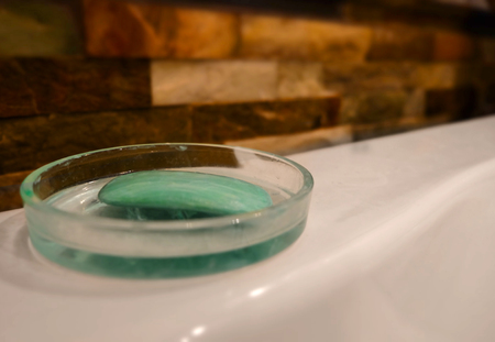 Soap in dish on a tub ledge telling you to wash up and get cleansed for hygiene and good health, with blank copy spaceの写真素材