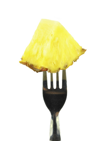slice of pineapple on a fork on a white background の写真素材