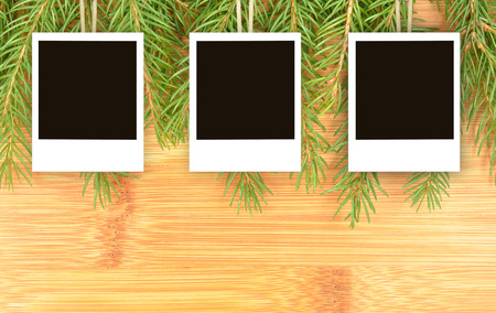 hanging pictures and spruce twigs on a wooden backgroundの写真素材