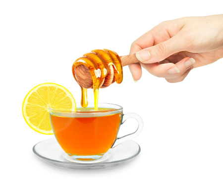 tea with honey and hand isolated on whiteの写真素材