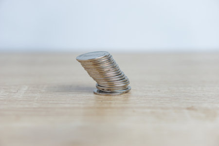 Stack of coins tilted on a table with a white background