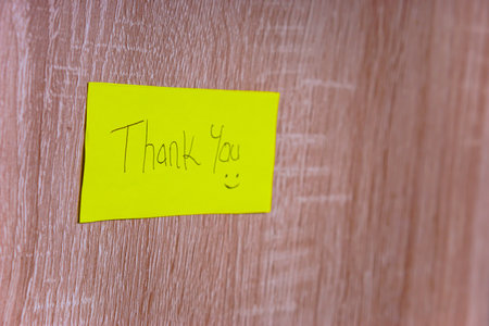 A cheerful note saying "Thank You" on a bright yellow sticky note, enhancing positivity in any space.の写真素材