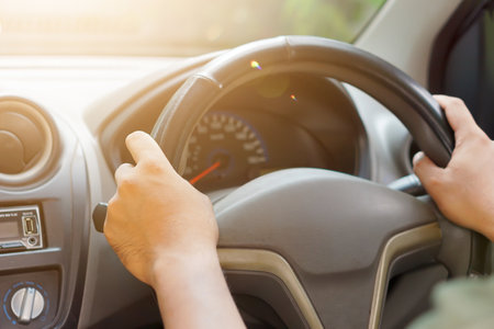close up A person gripping the steering wheel of a car, focused on driving.の写真素材