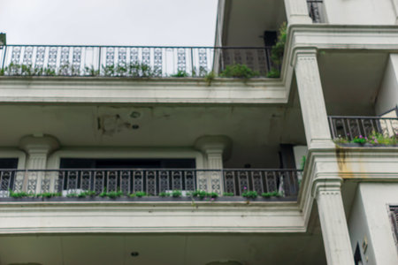An aged building with decorative balconies and greenery enhances its urban charm.の写真素材