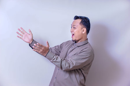 An asian man gestures animatedly, expressing surprise or excitement.