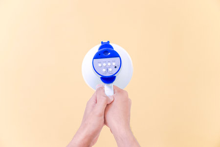 a hand hold megaphone speaker isolated on beige backgroundの写真素材