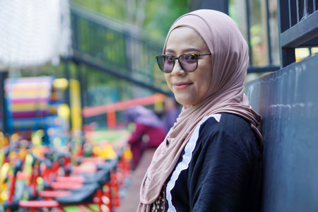 A joyful asian woman in a hijab smiling