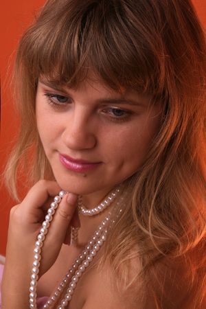 Sexy young woman with a pearl necklace over red backgroundの写真素材