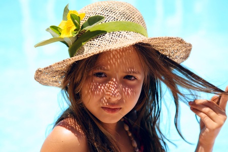 Little girl wearing a hat near poolの写真素材