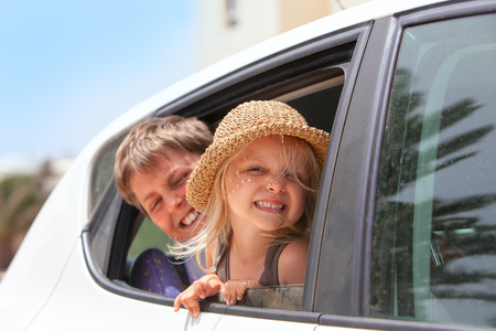 Off to the beach!   Portrait of two happy children inside the car .の写真素材