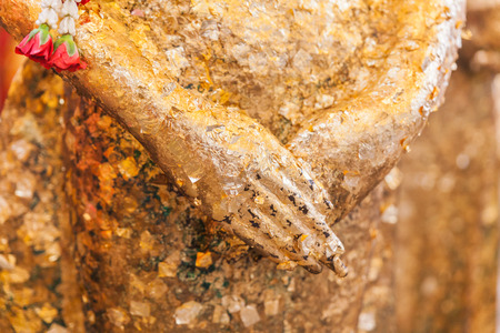 Closeup hand of gilded ancient buddha statueの写真素材