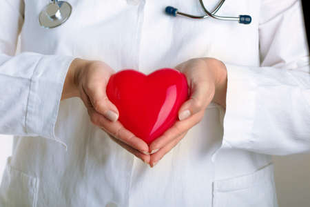 female doctor holding red heart
