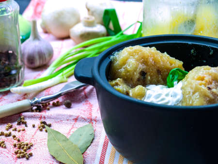 Gnocchi potatoes baked in a creamy sauce with Basil in a cast iron pot on the kitchen backgroundの写真素材