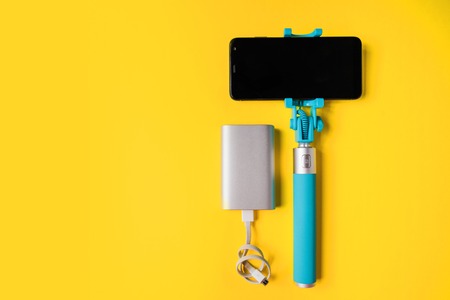 Set for photographing and traveling monopods with smartphone for selfie and power bank. Stick with smartphone isolatedの写真素材