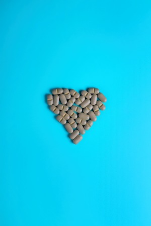 Natural Supplements in the form of a heart on a light background. The concept of alternative medicine.の写真素材