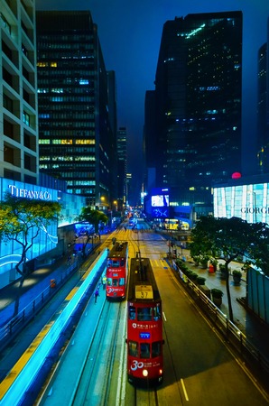 HONG KONG, CHINA - APRIL 29, 2014: Hong Kongs night life. Two red trams pass along the street with the shops of Tiffany Co. and Georgia Armaniのeditorial素材