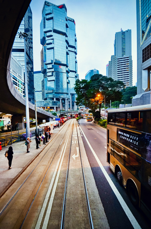 HONG KONG, CHINA - APRIL 29, 2014: View from the tramway to the skyscrapers and the roads of Hong Kong. People at the bus stop waiting for transport.のeditorial素材