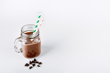 Protein shake, smoothie with chocolate and cocoa in a jar on a white backgroundの写真素材