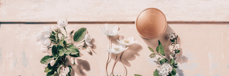 Natural organic cosmetics: serum, cream, mask on wooden background with flowers. Skincare concept