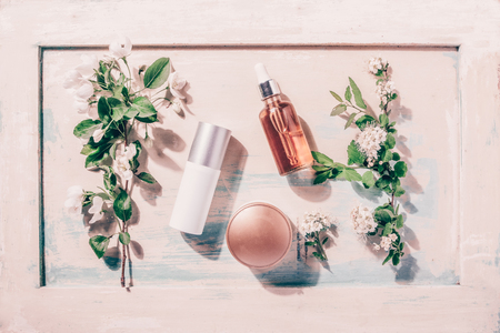 Natural organic cosmetics: serum, cream, mask on wooden background with flowers. Skincare conceptの写真素材