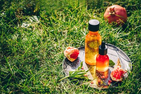 Pomegranate seed oil, whey in different bottles on a decorative grater. Lifestyle. The concept anti-aging skin careの写真素材