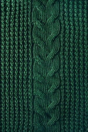 Knitted texture background of a winter green high neck sweater. Hipset style