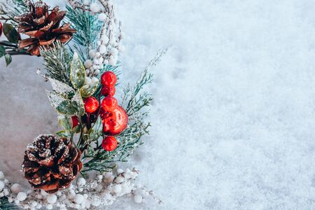 Beautiful christmas wreath frame on fresh white snow. Minimal winter vacation idea. Flat lay top view composition.の写真素材