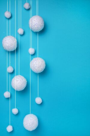 Christmas composition. The concept of a winter festive background, snowfall from white balls on a blue background. Christmas, winter, new year concept. Minimalism flat layの写真素材