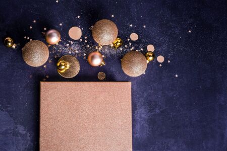 Christmas composition. Christmas present concept with golden decorations, balls, glitters on a dark blue background. Copy space Minimalism flat layの写真素材