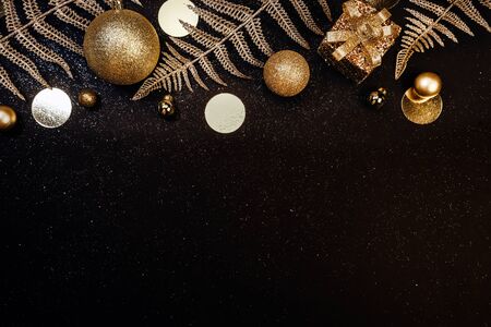 Christmas background. Holiday Gifts in white boxes with a festive decor and shiny branches on a black background with glitters. Flat lay, top view, copy spaceの写真素材