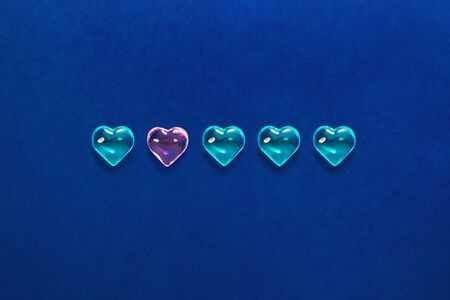 Glass blue hearts on a classic blue background. Symbol of LGBT love, Saint Valentine. Minimalism