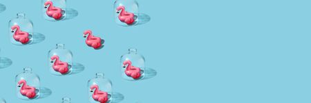 Quarantined summer, vacations canceled. Creative idea of isolation COVID-19 virus pandemic coronavirus infection. Sad flamingo isolated under capの写真素材