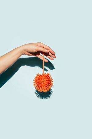 Female hand with a virus image on a blue background. Trendy art concept of virus infection. Coronavirus concept, contrasting shadows, minimalism.の写真素材