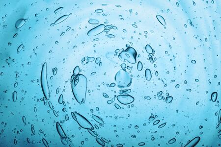 Water texture with bubbles Hyaluronic acid cosmetic gel. Gel texture with bubbles on a blue...