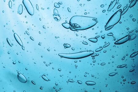 Water texture with bubbles Hyaluronic acid cosmetic gel. Gel texture with bubbles on a blue...
