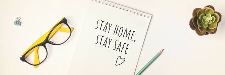 Words stay home, stay safe written in notebook, concept of self quarantine at home as preventative...