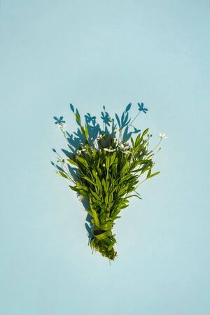 Delicate bouquet of little flowers on a yellow background. Flat lay summer concept. Minimalism.の写真素材