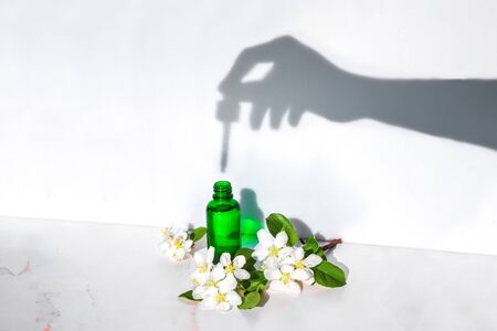 Natural cosmetics serum, extracts and oils for skin and hair care in a bottle with a pipette. The...