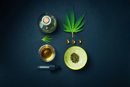 Medical CBD oil on black trendy background with cannabis leaves. The concept of medical tincture of marijuana. Trendy Flat Lay Minimalismの写真素材