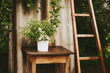 A bouquet of wildflowers and chamomiles on a wooden table. Flowers on a wooden table, rustic bouquet...