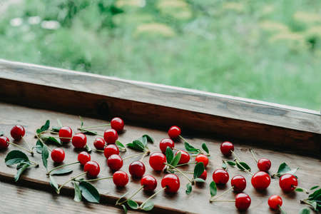 Ripe cherries on a wooden windowsill. Cottagecore Aesthetics. Rustic, vintage style Juicy summer...
