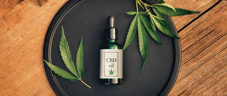 Cannabs medical product, CBD oil, with hemp leaves on a black dish on a wooden table. Flat lay. Mockup Copy spaseの写真素材