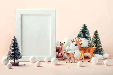 Christmas mockup frame with a decor of deer, fir trees and decorative snow. Happy Christmas and New...